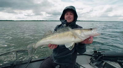 a man on a boat holding a large fish