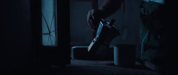 a person holding a knife in a dark room