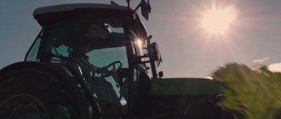 a tractor with the sun shining behind it