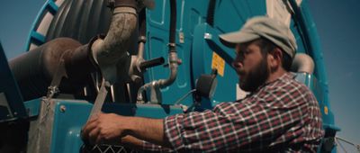 a man in plaid shirt working on a machine