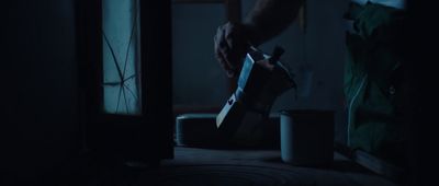 a person holding a knife in a dark room