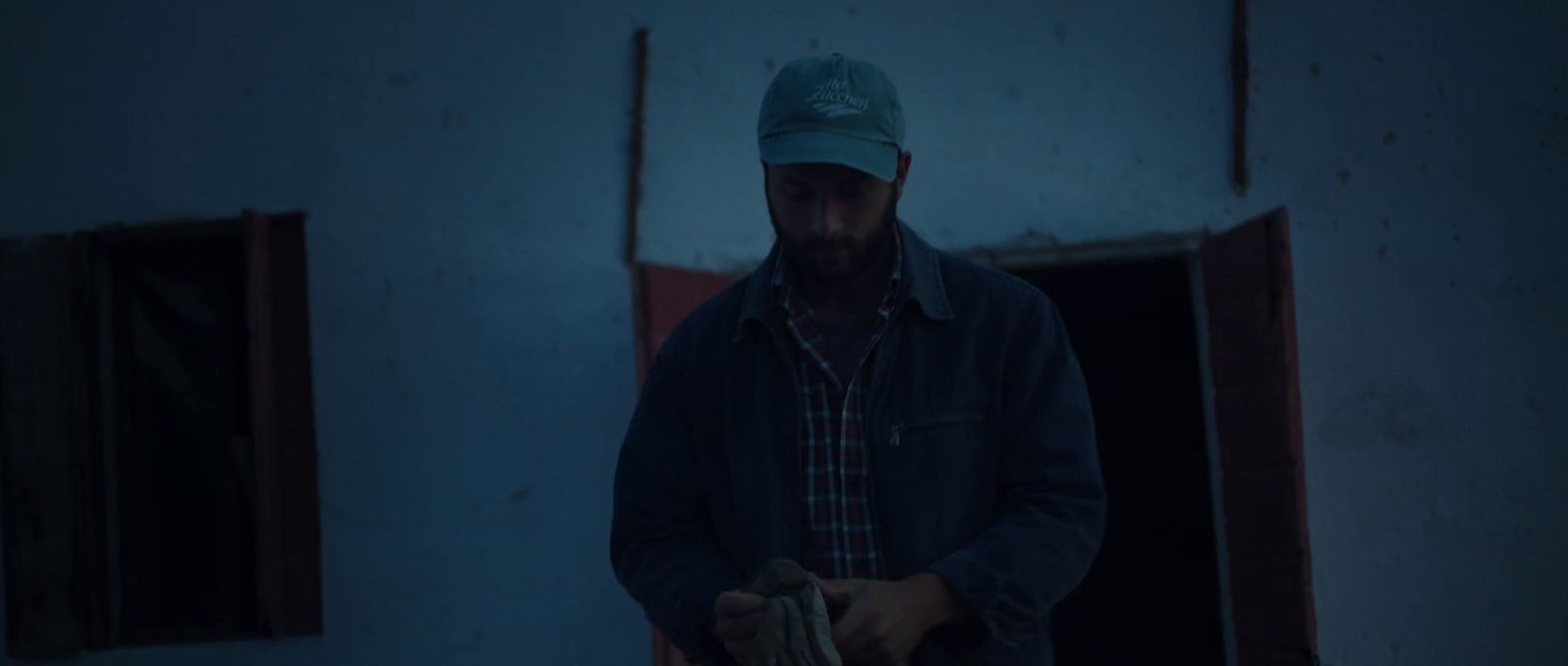 a man in a blue hat standing in a doorway