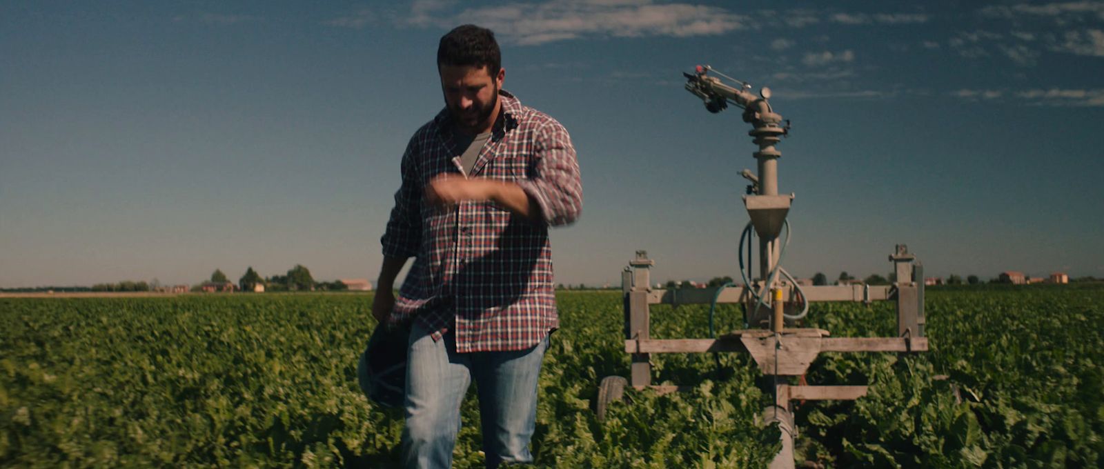 a man standing in a field next to a camera