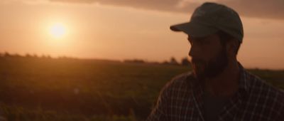 a man standing in a field at sunset