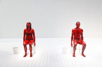 a couple of red plastic figures sitting next to each other