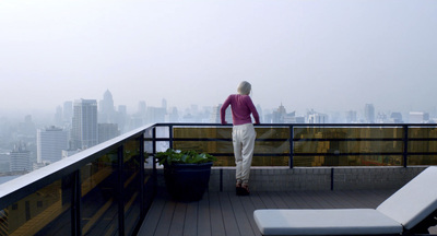 a woman standing on a balcony overlooking a city