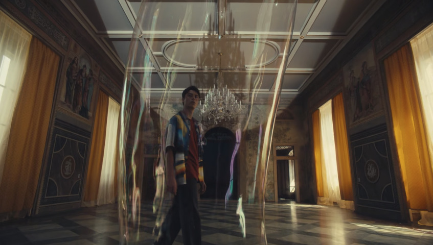 a man is standing in a room with a chandelier