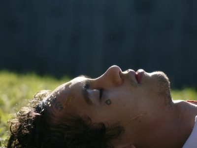 a man laying in the grass with his eyes closed