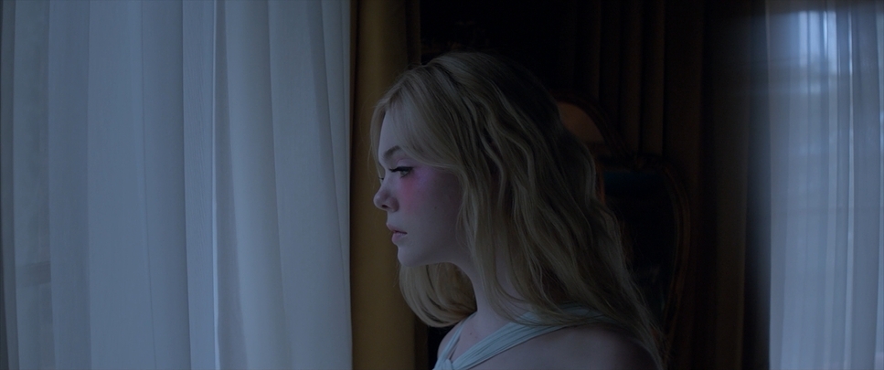 a young blonde girl looking out of a window