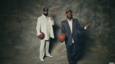 a couple of men standing next to each other holding basketballs