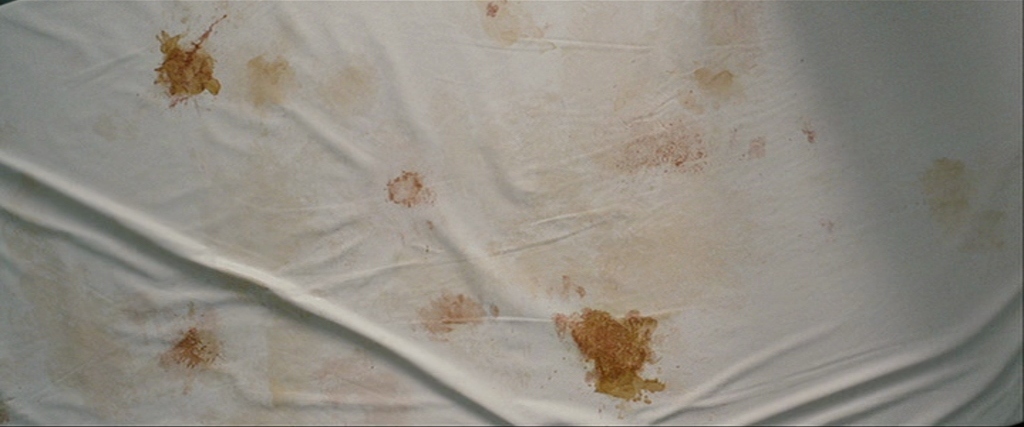 a white sheet with brown spots on it