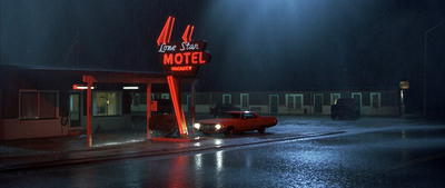 a red car is parked in front of a motel