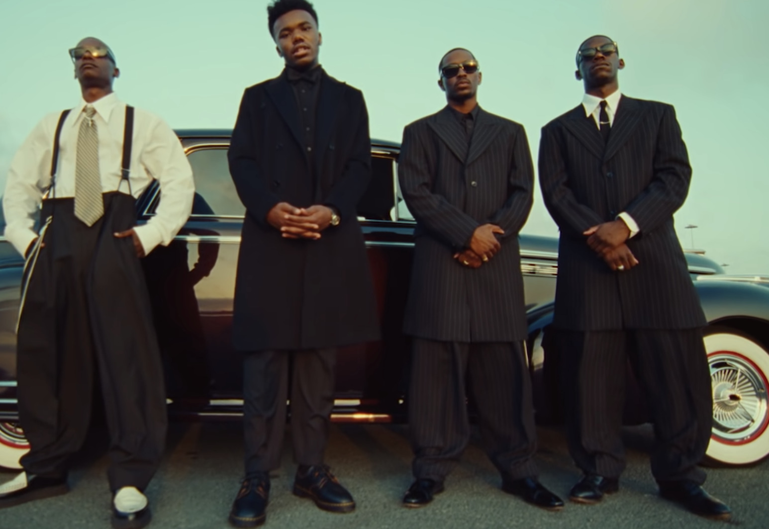 a group of men standing next to a car