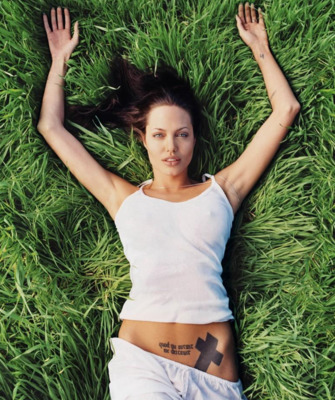 a woman laying on top of a lush green field