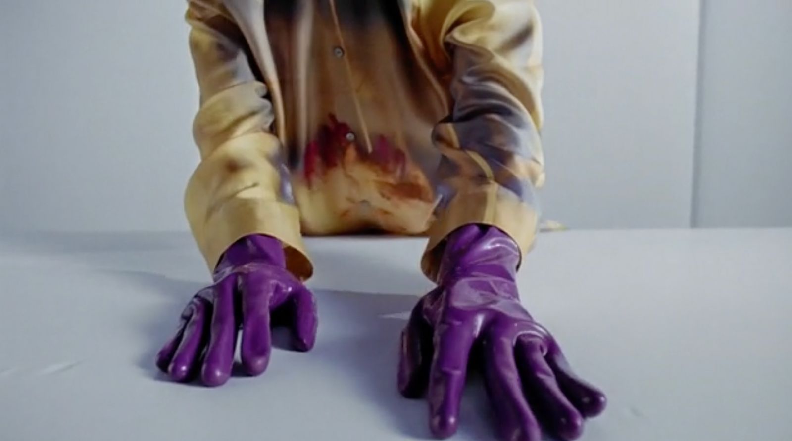 a person wearing purple gloves and a white shirt