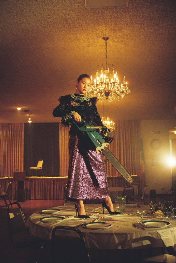 a woman standing on a table holding a guitar