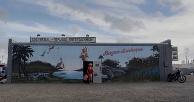 a woman standing in front of a mural on the side of a building