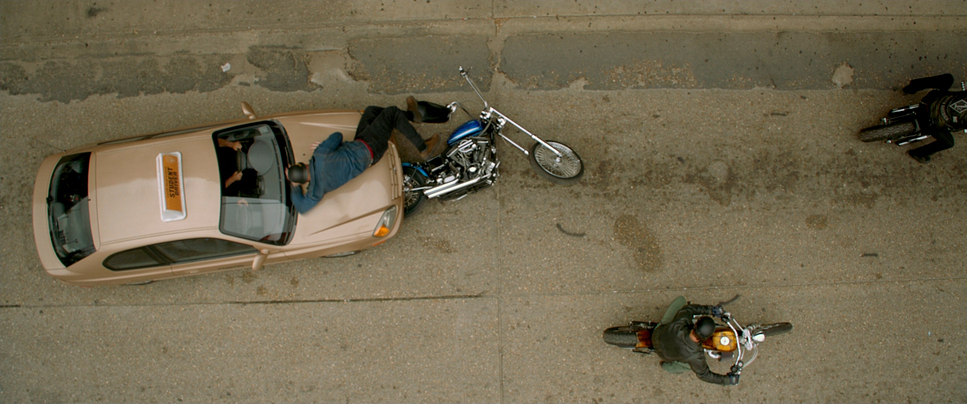 a car parked next to a motorcycle on a sidewalk