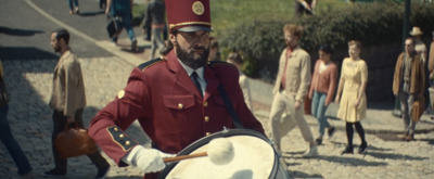 a man is playing a drum in front of a crowd of people