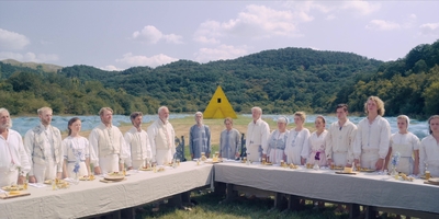 a group of people standing around a table with food on it