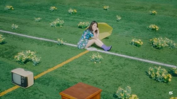 a woman sitting on the ground with an umbrella