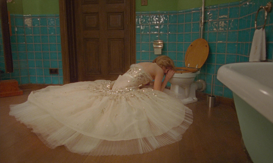 a woman in a dress is kneeling down in front of a toilet