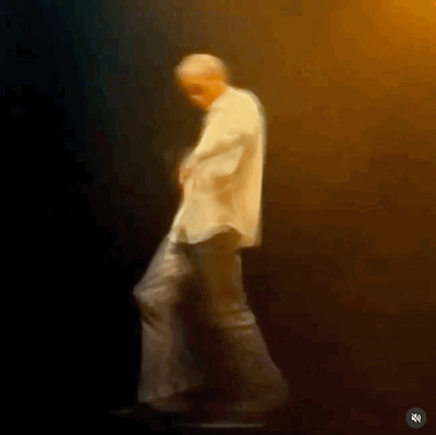 a blurry image of a man walking on a stage