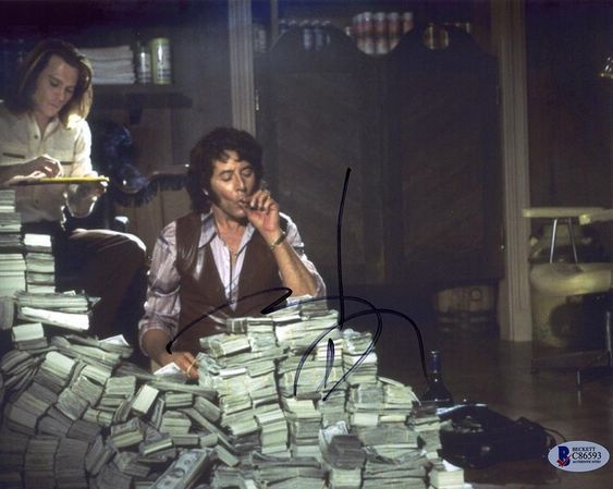 a man sitting in front of a pile of money