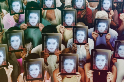 a group of people holding up pictures of themselves