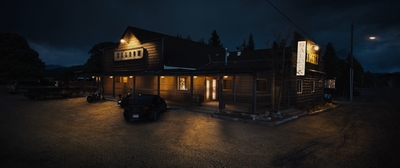 a large wooden building with a car parked in front of it