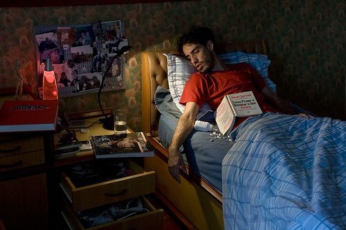 a man laying in bed with a book in his hand