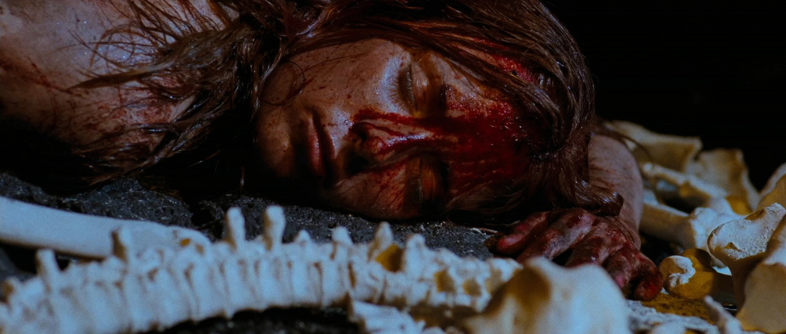 a woman with blood on her face laying on the ground