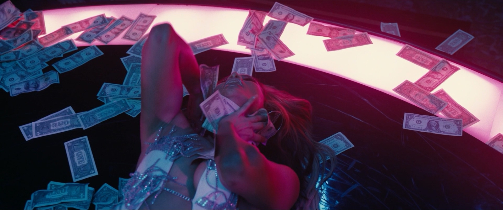 a woman holding a cell phone in front of a bunch of money