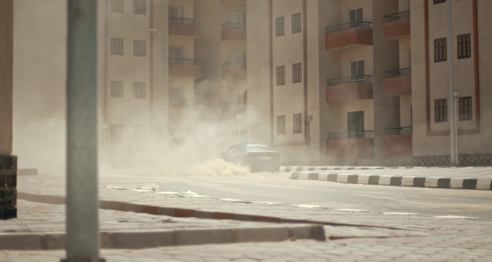 a car driving down a street next to tall buildings