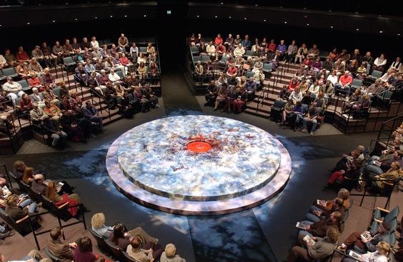 a large group of people sitting in front of a stage