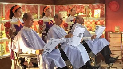 a group of people sitting in a barber shop