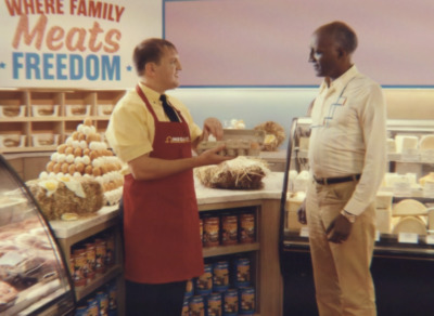 a man in an apron talking to a man in an apron