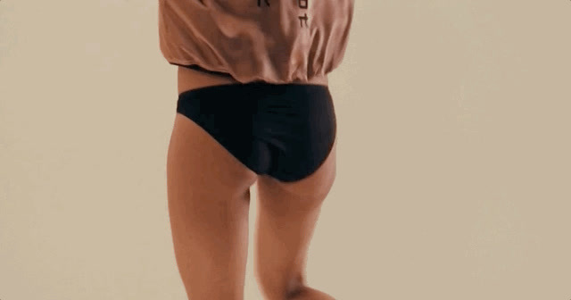 a woman in a brown shirt and black shorts