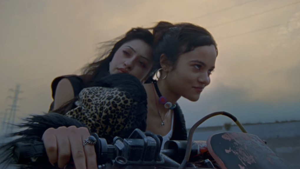 two women riding a motorcycle on a deserted road