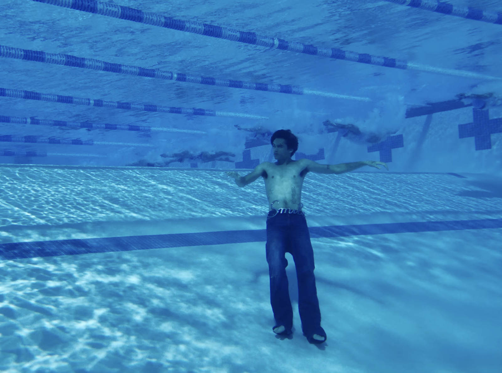 a man standing in a pool with his arms outstretched