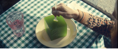 a person is holding a piece of green food on a plate