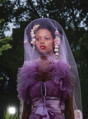 a woman in a purple dress with a veil over her head