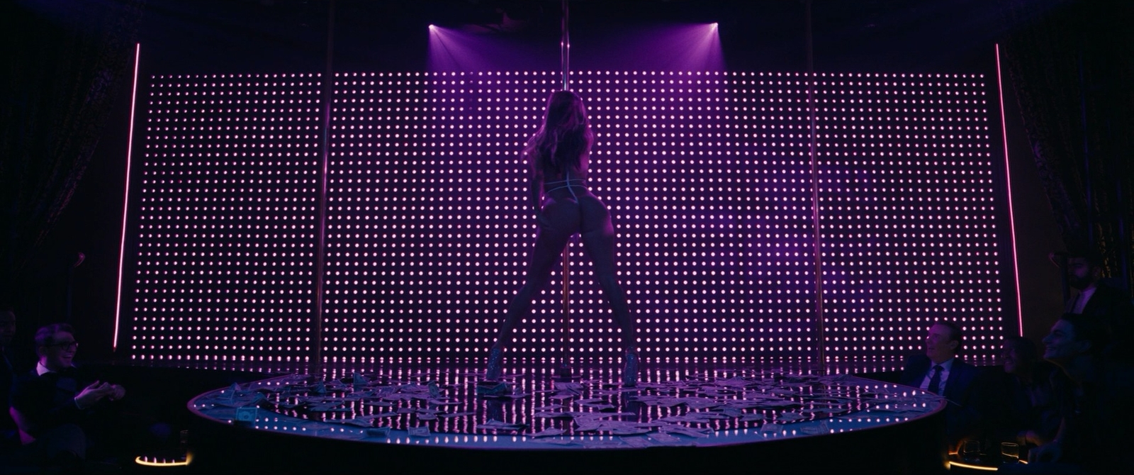 a person standing on a stage in front of a purple light