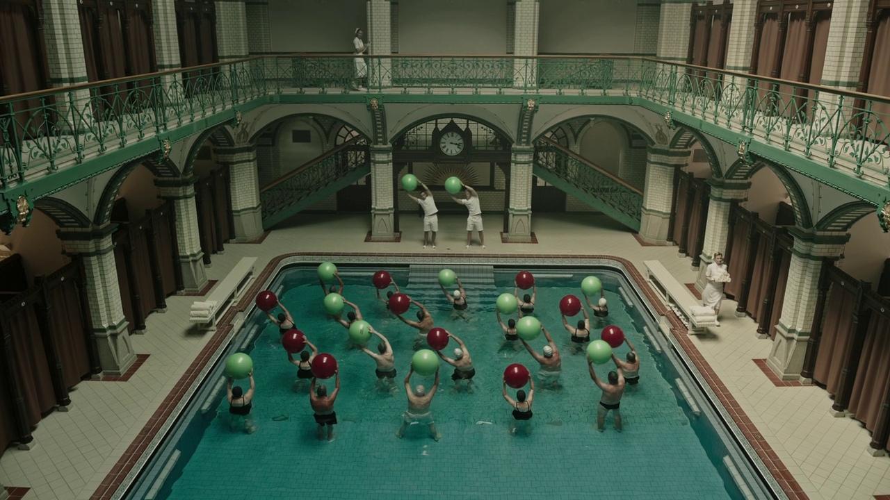 a group of people standing around a swimming pool