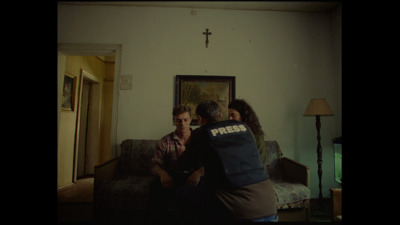 three people sitting on a couch in a living room