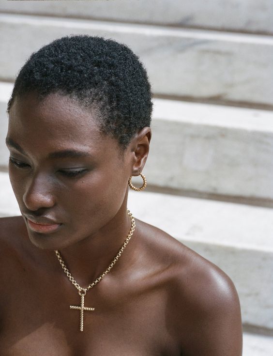 a woman wearing a cross necklace and earrings