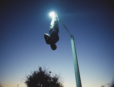 a person hanging upside down from a street light