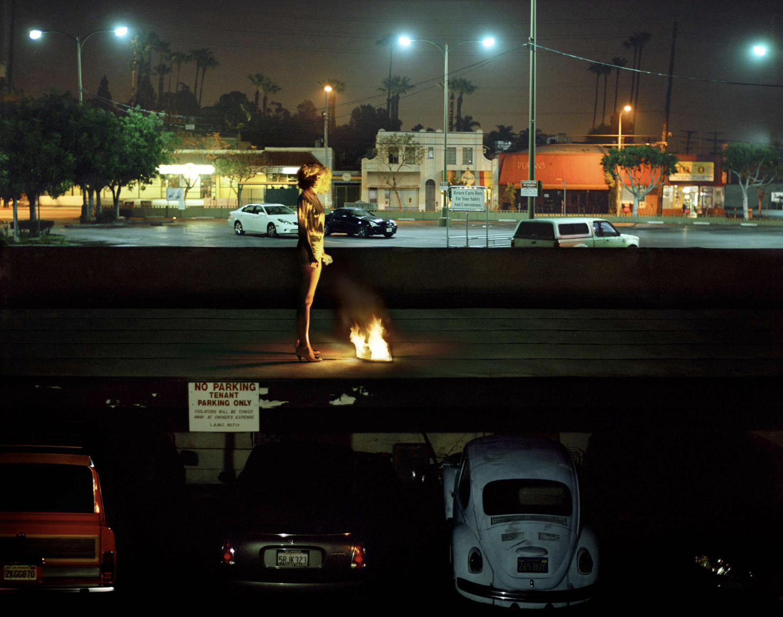 a woman standing in the middle of a parking lot