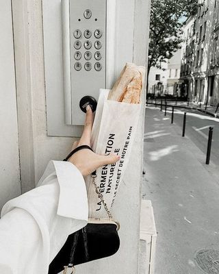 a woman in a white coat is holding a bag