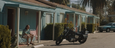 a woman sitting on a chair next to a motorcycle